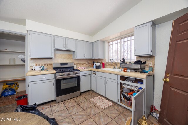123 Marquita Ln, El Paso, TX 79915 - kitchen with gas range, vaulted ceiling, backsplash, light countertops, and light tile patterned floors
