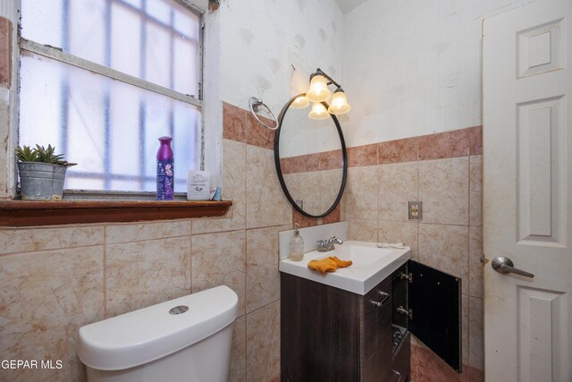 123 Marquita Ln, El Paso, TX 79915 - bathroom featuring tile walls, vanity, and a wainscoted wall