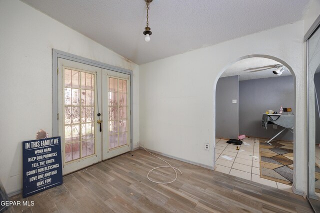 123 Marquita Ln, El Paso, TX 79915 - doorway with arched walkways, french doors, vaulted ceiling, wood finished floors, and a textured ceiling