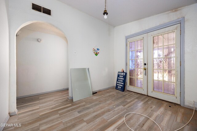 123 Marquita Ln, El Paso, TX 79915 - dining space featuring french doors, wood finished floors, and arched walkways