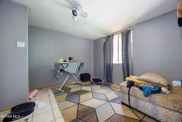 123 Marquita Ln, El Paso, TX 79915 - bedroom with a textured ceiling and tile patterned floors