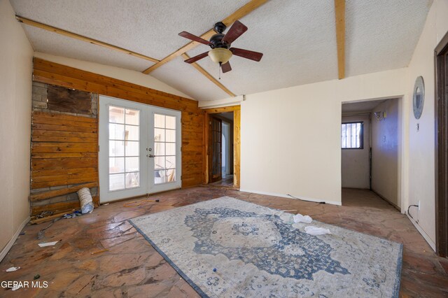 123 Marquita Ln, El Paso, TX 79915 - empty room featuring french doors, a ceiling fan, vaulted ceiling, stone floors, and a textured ceiling