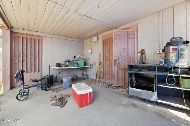 123 Marquita Ln, El Paso, TX 79915 - miscellaneous room featuring unfinished concrete flooring and wood walls