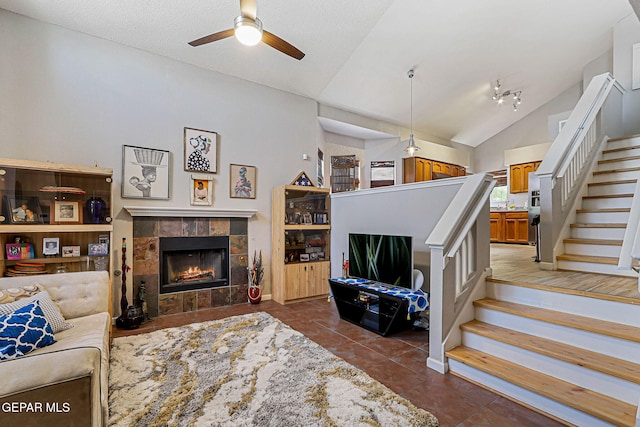 700 Milton Henry Ave, El Paso, TX 79932 - tiled living room featuring vaulted ceiling, a tile fireplace, stairway, and ceiling fan