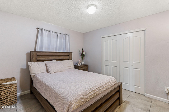 700 Milton Henry Ave, El Paso, TX 79932 - bedroom with a closet, a textured ceiling, and light tile patterned floors