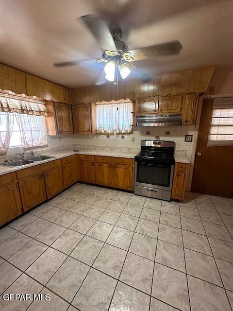 7190 Fatima Ave, El Paso, TX 79915 - kitchen featuring gas range, under cabinet range hood, brown cabinets, and light countertops