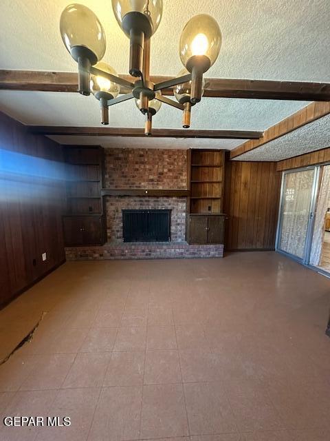 7190 Fatima Ave, El Paso, TX 79915 - unfurnished living room featuring wood walls, beamed ceiling, and a brick fireplace