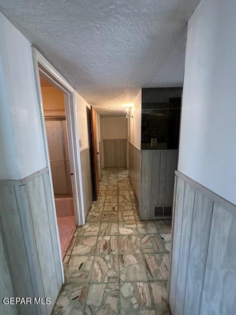 7190 Fatima Ave, El Paso, TX 79915 - corridor with a wainscoted wall and a textured ceiling