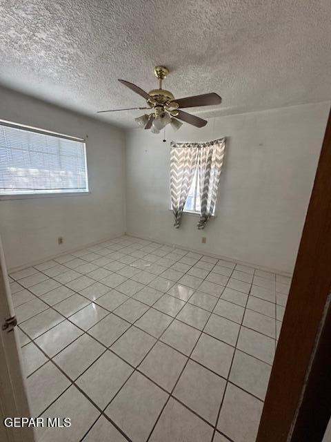 7190 Fatima Ave, El Paso, TX 79915 - spare room featuring light tile patterned flooring, a textured ceiling, and a ceiling fan