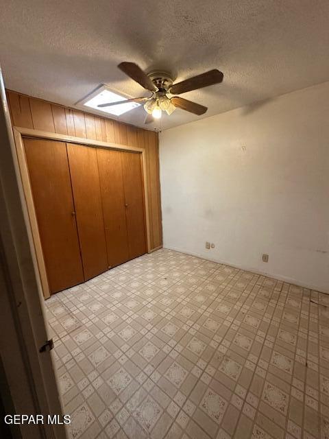 7190 Fatima Ave, El Paso, TX 79915 - unfurnished bedroom featuring a textured ceiling, a closet, a skylight, and ceiling fan