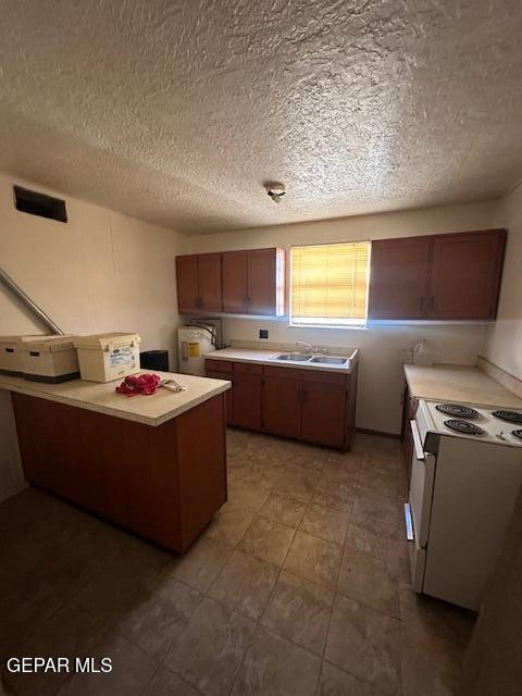 7190 Fatima Ave, El Paso, TX 79915 - kitchen with white electric range oven, light countertops, a textured ceiling, a peninsula, and brown cabinetry