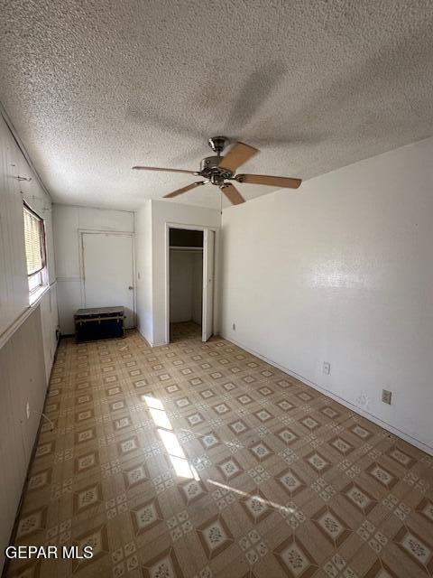 7190 Fatima Ave, El Paso, TX 79915 - unfurnished bedroom with a textured ceiling, a closet, and a ceiling fan