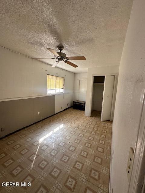 7190 Fatima Ave, El Paso, TX 79915 - unfurnished bedroom with multiple closets, light flooring, a textured ceiling, and a ceiling fan