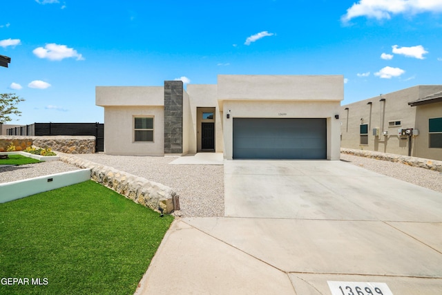 13699 Kathys Ct, El Paso, TX 79928 - pueblo-style house featuring an attached garage, stucco siding, concrete driveway, and a front yard