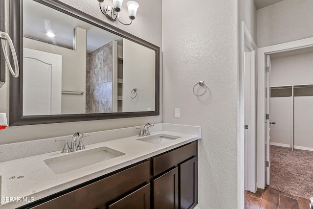 5465 Limestone Dr, El Paso, TX 79934 - full bath featuring a textured wall, double vanity, and wood finished floors