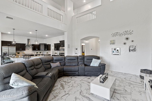 3725 Surmise St, El Paso, TX 79938 - living room featuring arched walkways, light marble finish floors, and recessed lighting