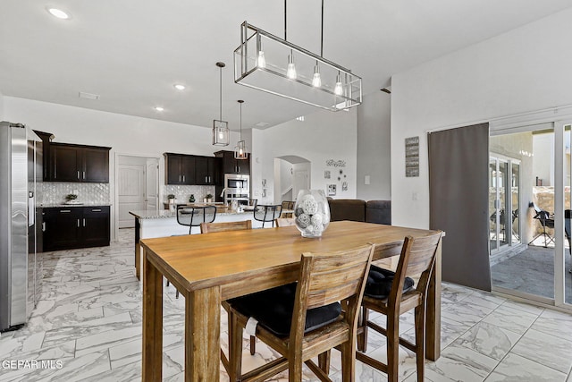 3725 Surmise St, El Paso, TX 79938 - dining room with light marble finish floors, arched walkways, and recessed lighting