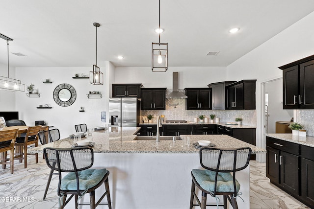 3725 Surmise St, El Paso, TX 79938 - kitchen featuring wall chimney exhaust hood, stainless steel fridge, light marble finish floors, tasteful backsplash, and recessed lighting
