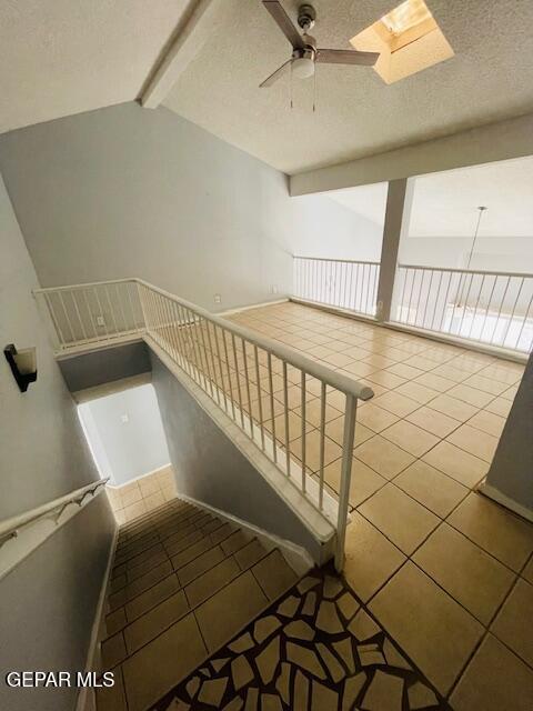 10940 Golden Pond Dr, El Paso, TX 79934 - stairs with ceiling fan, tile patterned flooring, a skylight, and a textured ceiling