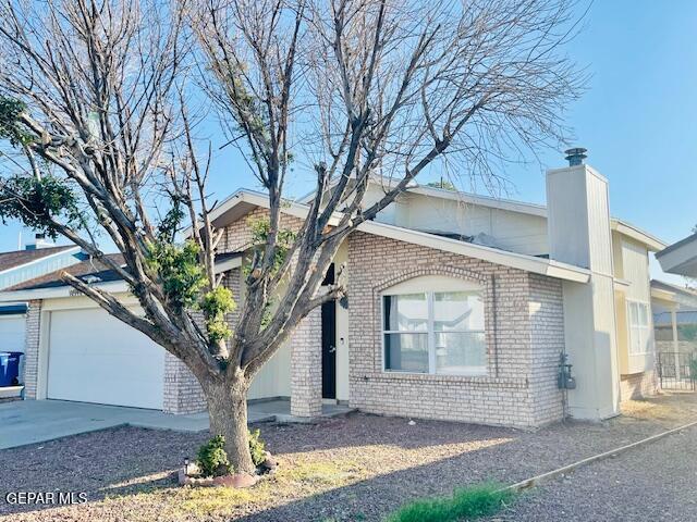 10940 Golden Pond Dr, El Paso, TX 79934 - view of front of property with brick siding, a garage, a chimney, and concrete driveway