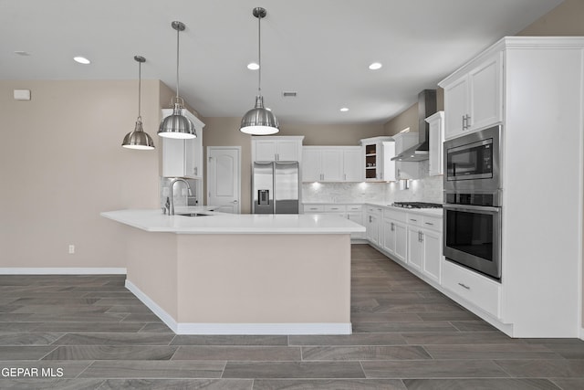 912 Malven Pl, El Paso, TX 79928 - kitchen featuring appliances with stainless steel finishes, wall chimney range hood, tasteful backsplash, pendant lighting, and white cabinetry