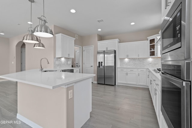 912 Malven Pl, El Paso, TX 79928 - kitchen featuring stainless steel appliances, arched walkways, a peninsula, backsplash, and white cabinetry