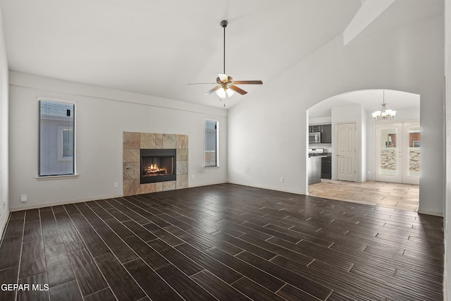 4609 Al Hernandez St, El Paso, TX 79938 - unfurnished living room featuring a chandelier, ceiling fan, wood finished floors, a fireplace, and arched walkways