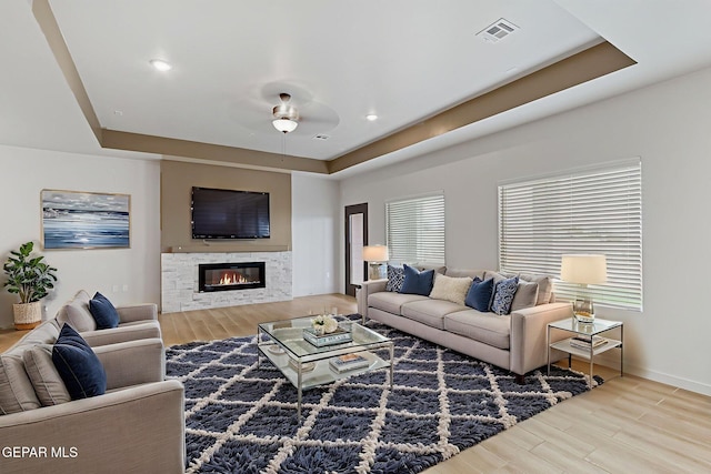 248 Farnborough St, El Paso, TX 79928 - living room featuring wood finished floors, a tray ceiling, a glass covered fireplace, and a ceiling fan