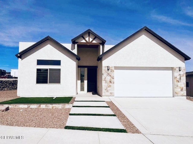 7601 Enchanted Ridge Dr, El Paso, TX 79911 - view of front of house featuring stone siding, an attached garage, stucco siding, and concrete driveway