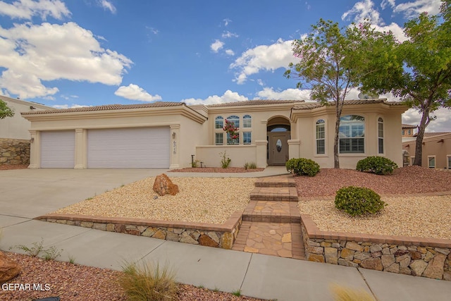 6316 Franklin Red Dr, El Paso, TX 79912 - mediterranean / spanish-style house featuring concrete driveway, an attached garage, stucco siding, and a tiled roof