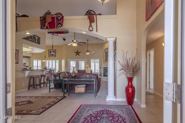 6316 Franklin Red Dr, El Paso, TX 79912 - living area featuring ceiling fan, arched walkways, light tile patterned flooring, ornate columns, and a towering ceiling