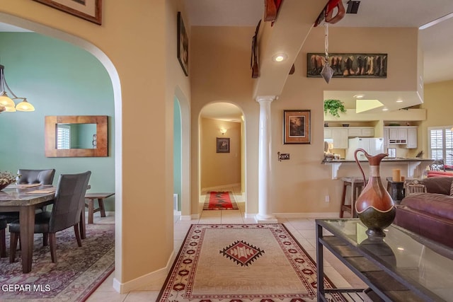 6316 Franklin Red Dr, El Paso, TX 79912 - living area featuring ornate columns, arched walkways, light tile patterned floors, and a towering ceiling