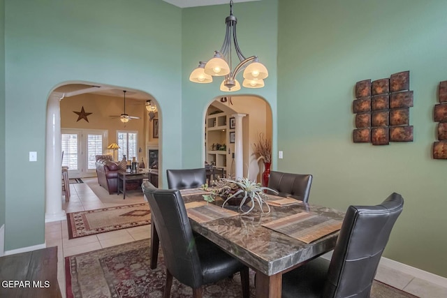 6316 Franklin Red Dr, El Paso, TX 79912 - tiled dining space featuring arched walkways, a high ceiling, ceiling fan, and a chandelier