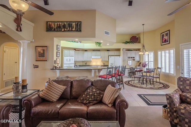 6316 Franklin Red Dr, El Paso, TX 79912 - living area featuring decorative columns, a towering ceiling, a ceiling fan, and light tile patterned floors