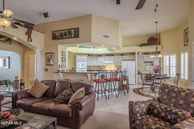 6316 Franklin Red Dr, El Paso, TX 79912 - living room featuring a ceiling fan, light tile patterned flooring, a high ceiling, arched walkways, and ornate columns