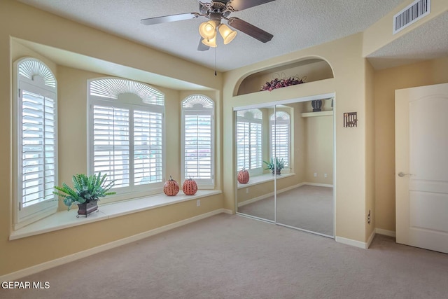 6316 Franklin Red Dr, El Paso, TX 79912 - unfurnished bedroom with carpet floors, multiple windows, a textured ceiling, a closet, and ceiling fan