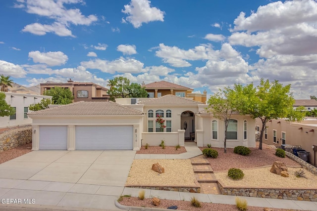 6316 Franklin Red Dr, El Paso, TX 79912 - mediterranean / spanish-style home featuring driveway, an attached garage, stucco siding, and a tile roof