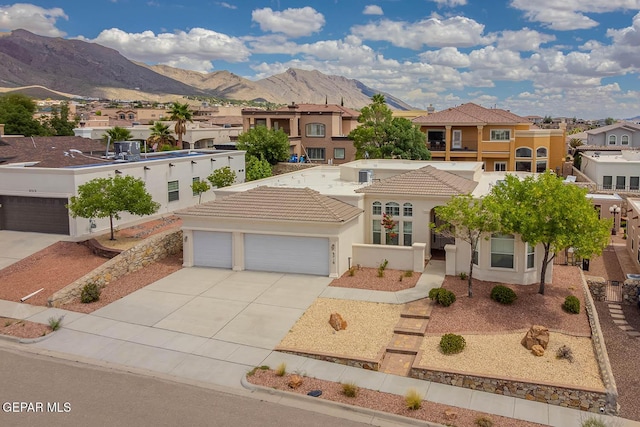 6316 Franklin Red Dr, El Paso, TX 79912 - mediterranean / spanish-style home featuring a mountain view, driveway, stucco siding, a tiled roof, and a garage
