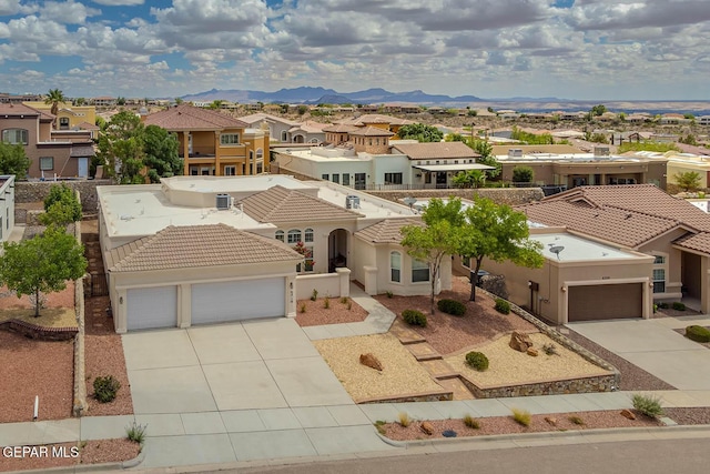 6316 Franklin Red Dr, El Paso, TX 79912 - mediterranean / spanish home with a residential view, concrete driveway, an attached garage, a tiled roof, and stucco siding