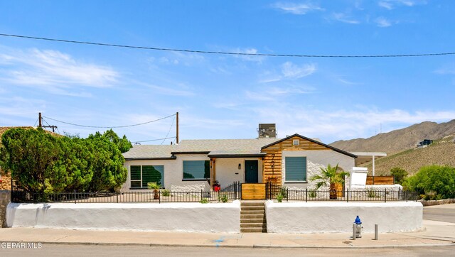 721 Mesita Dr, El Paso, TX 79902 - view of front of house featuring a fenced front yard, a mountain view, stucco siding, and a chimney