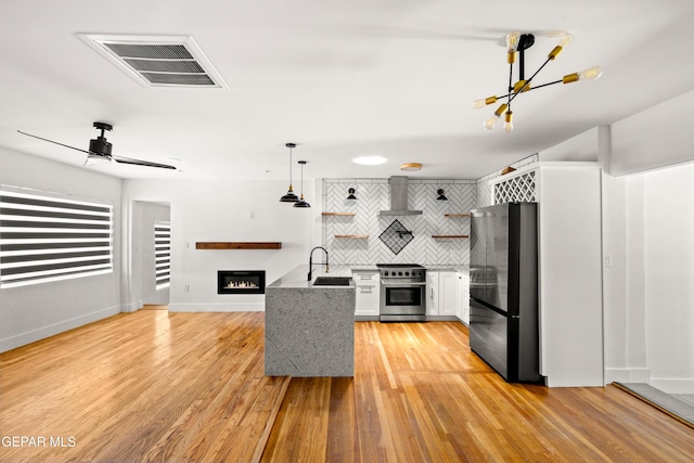 721 Mesita Dr, El Paso, TX 79902 - kitchen featuring stainless steel appliances, open shelves, a glass covered fireplace, decorative backsplash, and white cabinets