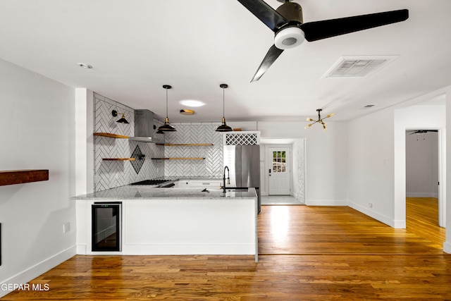721 Mesita Dr, El Paso, TX 79902 - kitchen featuring wine cooler, open shelves, tasteful backsplash, wall chimney exhaust hood, and a peninsula