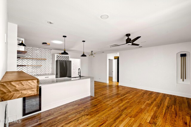 721 Mesita Dr, El Paso, TX 79902 - unfurnished living room featuring beverage cooler, ceiling fan, and wood finished floors