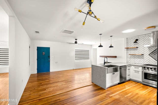 721 Mesita Dr, El Paso, TX 79902 - kitchen featuring appliances with stainless steel finishes, a peninsula, open shelves, backsplash, and light wood-type flooring