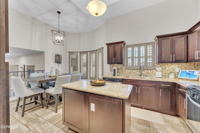 7817 Enchanted Trail Dr, El Paso, TX 79911 - kitchen with a towering ceiling, stainless steel appliances, light stone counters, a kitchen island, and decorative light fixtures