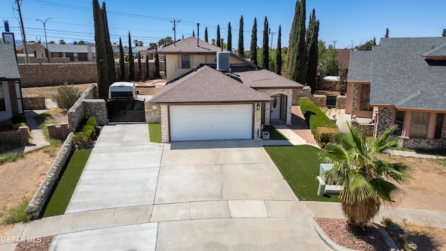 11713 Queens Garden Cir, El Paso, TX 79936 - view of front facade with concrete driveway, roof with shingles, a garage, a gate, and a residential view