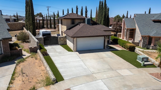 11713 Queens Garden Cir, El Paso, TX 79936 - view of front of property featuring a gate, concrete driveway, brick siding, a shingled roof, and a garage