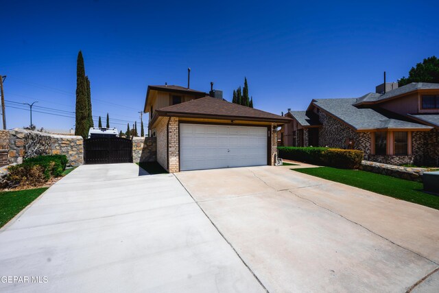 11713 Queens Garden Cir, El Paso, TX 79936 - view of front of home with a gate, driveway, brick siding, and a garage