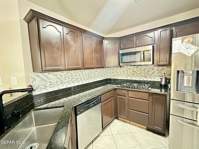 11713 Queens Garden Cir, El Paso, TX 79936 - kitchen with stainless steel appliances, tasteful backsplash, dark stone countertops, light tile patterned flooring, and lofted ceiling