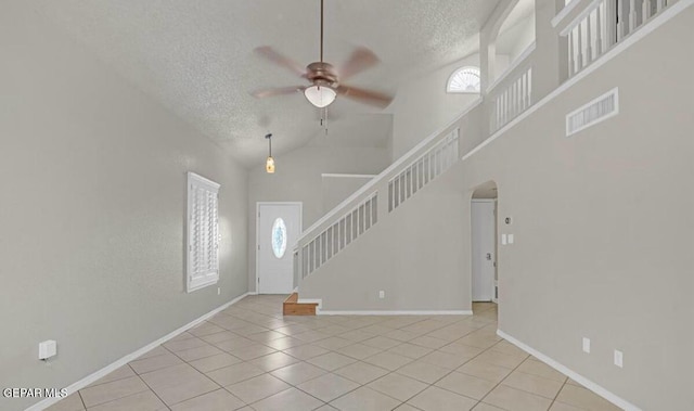 11713 Queens Garden Cir, El Paso, TX 79936 - unfurnished living room featuring a textured ceiling, a ceiling fan, tile patterned floors, stairway, and high vaulted ceiling